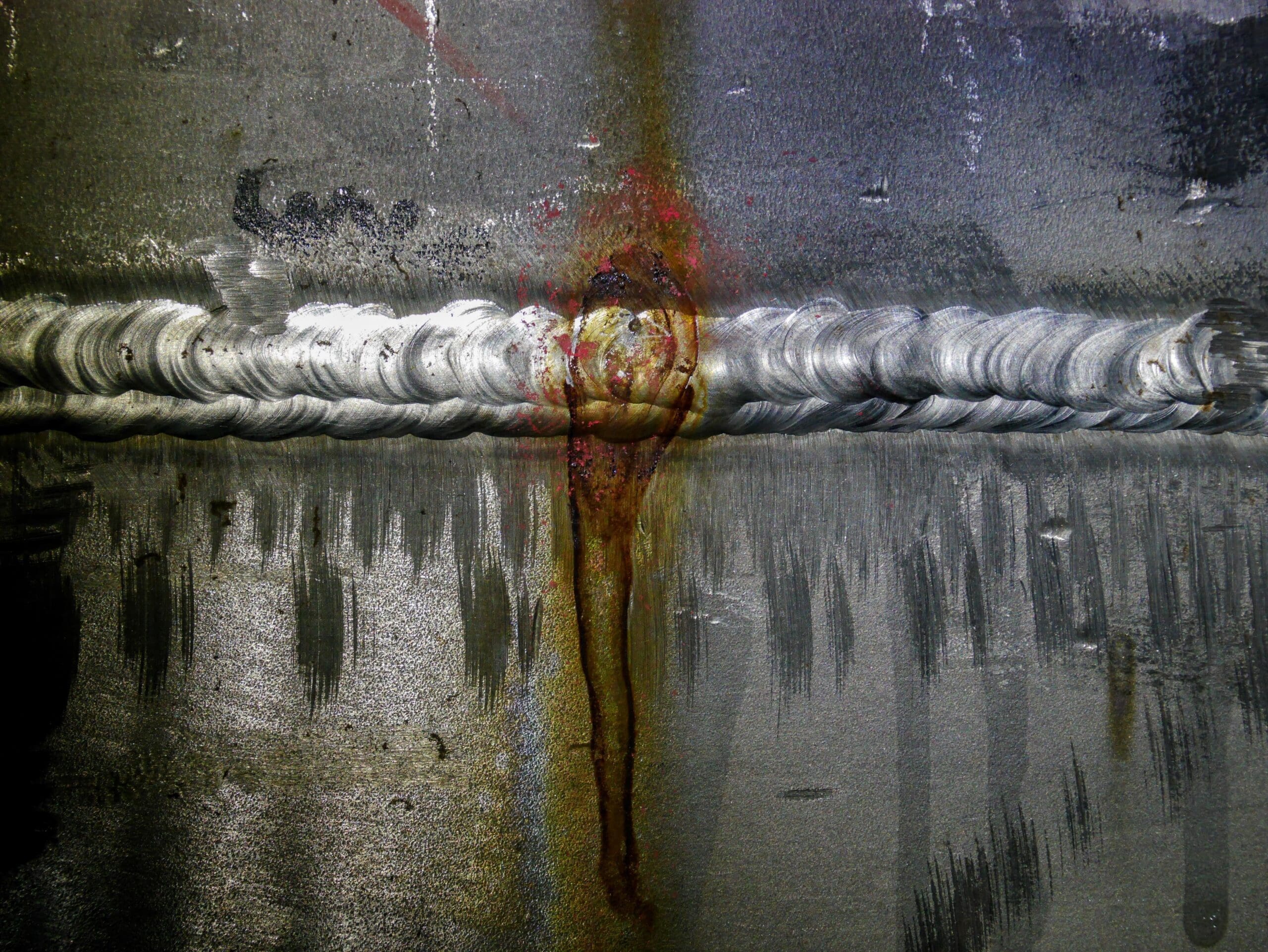 A close up image of a weld joint with corrosion damage