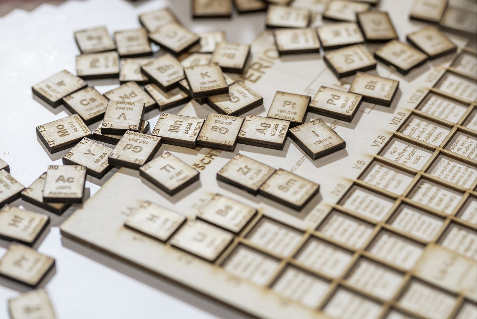 Wooden pieces with periodic elements engraved scattered across a table