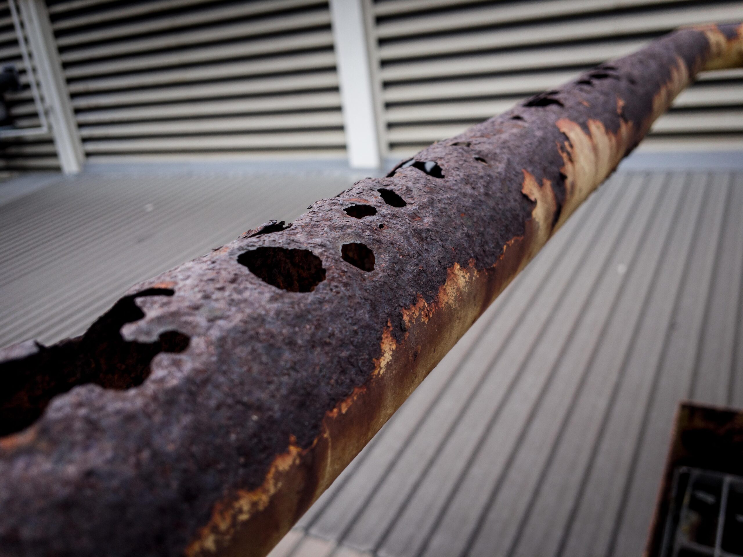 Close up of an industrial water pipe with visible corrosion and rust